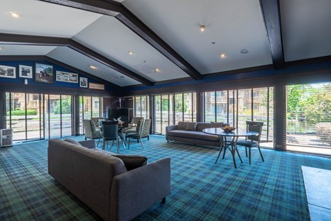 A large room with a couch, chairs, and a dining table.