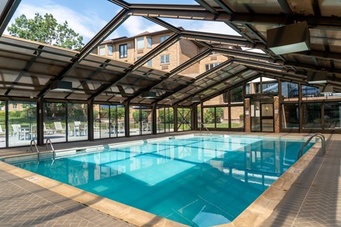 A large indoor swimming pool with a glass ceiling.