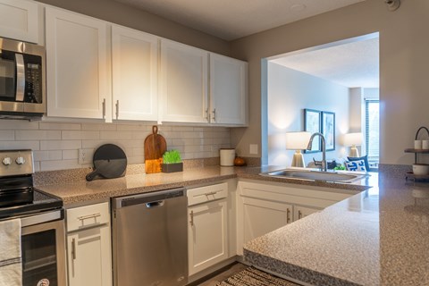 A kitchen with white cabinets and stainless steel appliances.