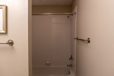 A bathroom with a glass shower door and a white door.