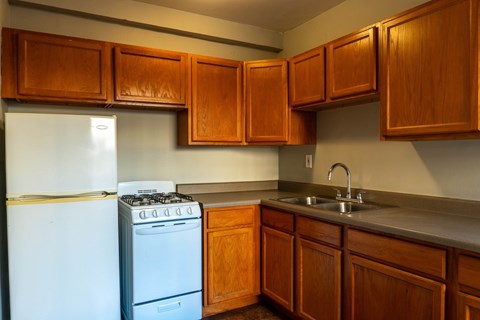 A kitchen with wooden cabinets and a white refrigerator.