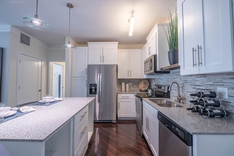 A kitchen with white cabinets and a granite countertop.