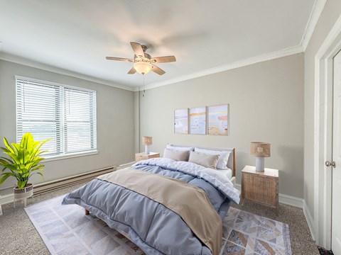 A bedroom with a bed, two lamps, and a ceiling fan.