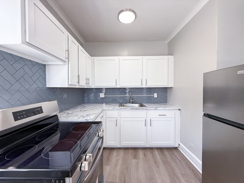 A kitchen with white cabinets and a black stove top oven.