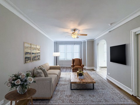 A living room with a couch, a chair, a coffee table, and a television.