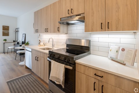 A modern kitchen with wooden cabinets and a white countertop.