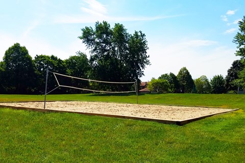 A volleyball net is set up on a sandy court.