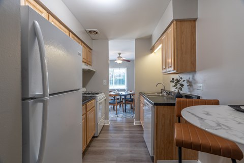 A kitchen with a refrigerator, table and chairs.