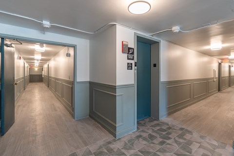 A long hallway with doors on both sides and a tiled floor.