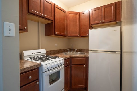 A kitchen with a white stove and refrigerator.