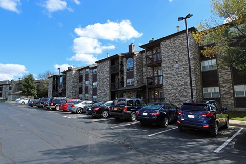 A parking lot with cars parked in front of a building.