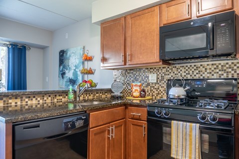 A kitchen with a black microwave above a stove.