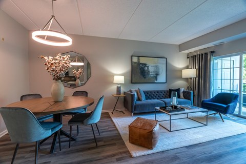 A modern living room with a dining table and chairs.