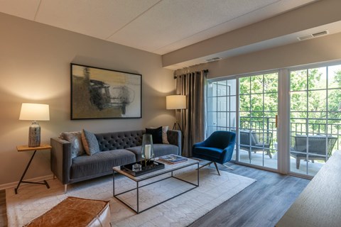 A living room with a grey couch, a blue chair, and a coffee table.