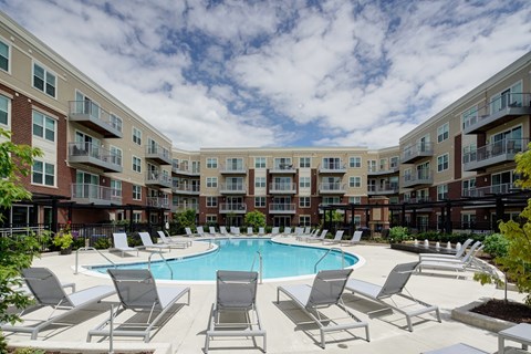 Resort style pool with loungers and courtyard seating at TLC Grand Apartments, Deerfield