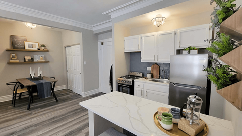 A kitchen with a table and chairs in the middle of the room.