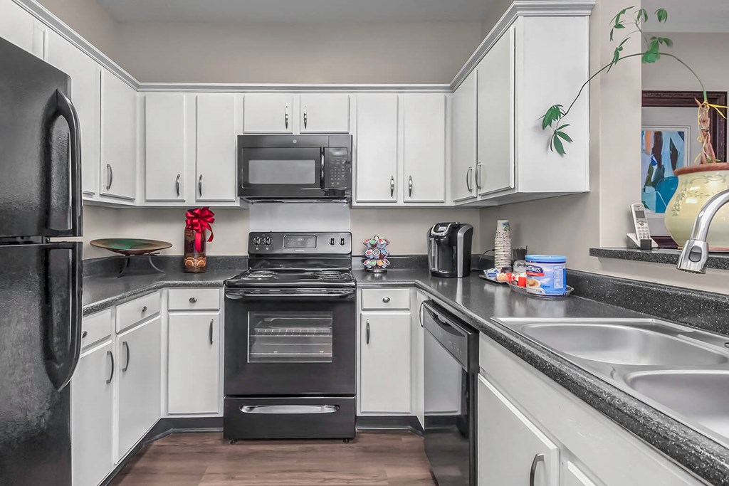 a kitchen with black appliances and white cabinets