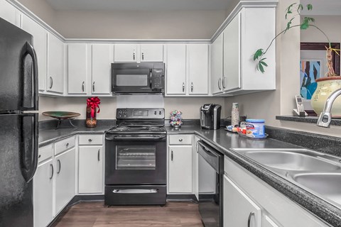 a kitchen with black appliances and white cabinets