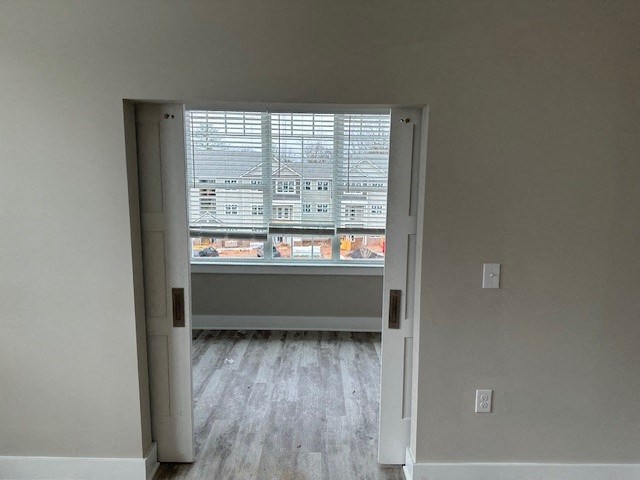 an empty room with a large window and wooden floors