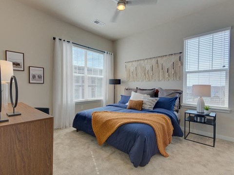 a bedroom with a bed and two windows