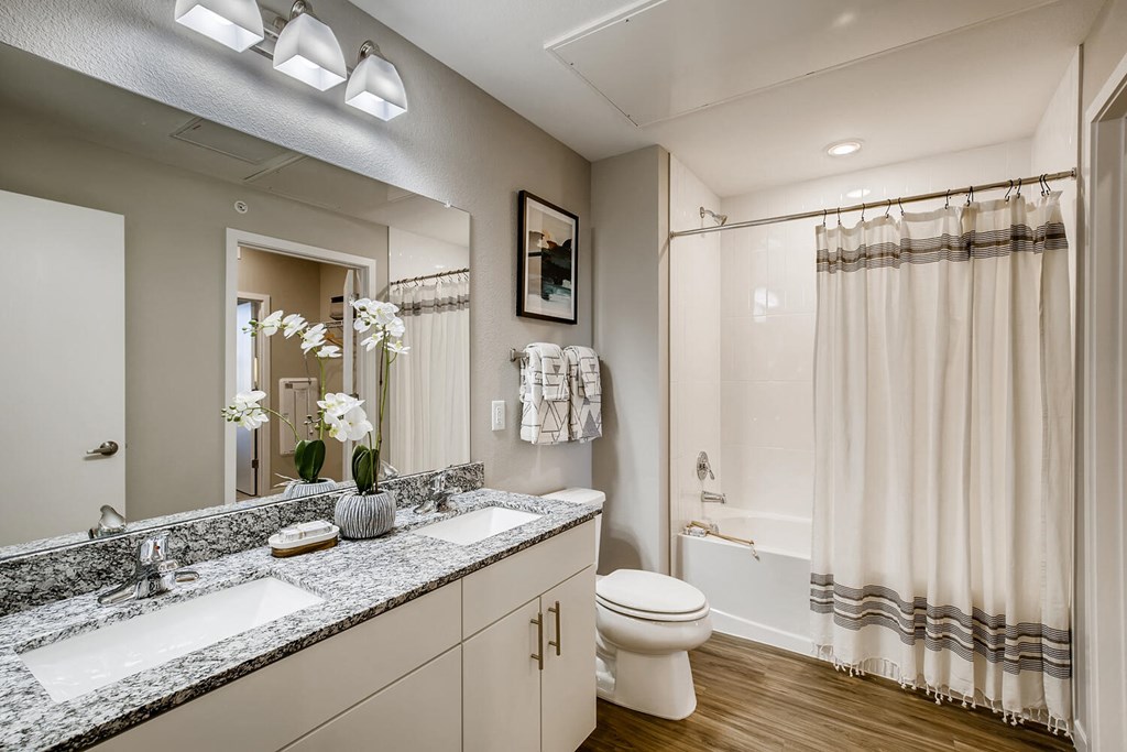 a bathroom with a shower and a sink and a toilet
