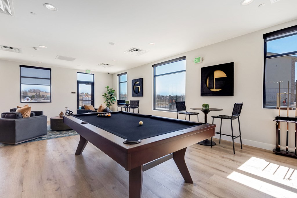 a games room with a pool table in the middle