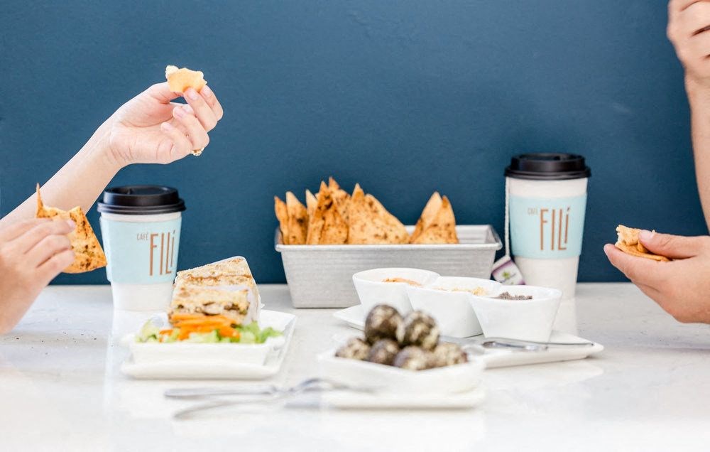 a table topped with plates of food and cups of coffee