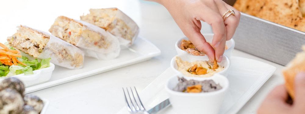 a person putting food on a plate on a table