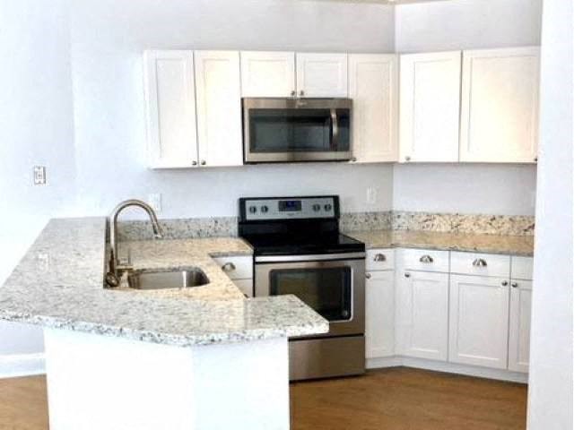 a kitchen with a stove a sink and a microwave