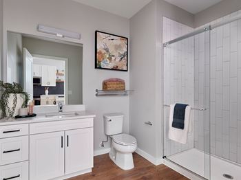 A white toilet sits in a bathroom next to a walk-in shower.
