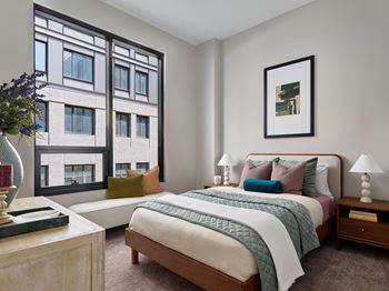 A bedroom with a large bed and a large window.