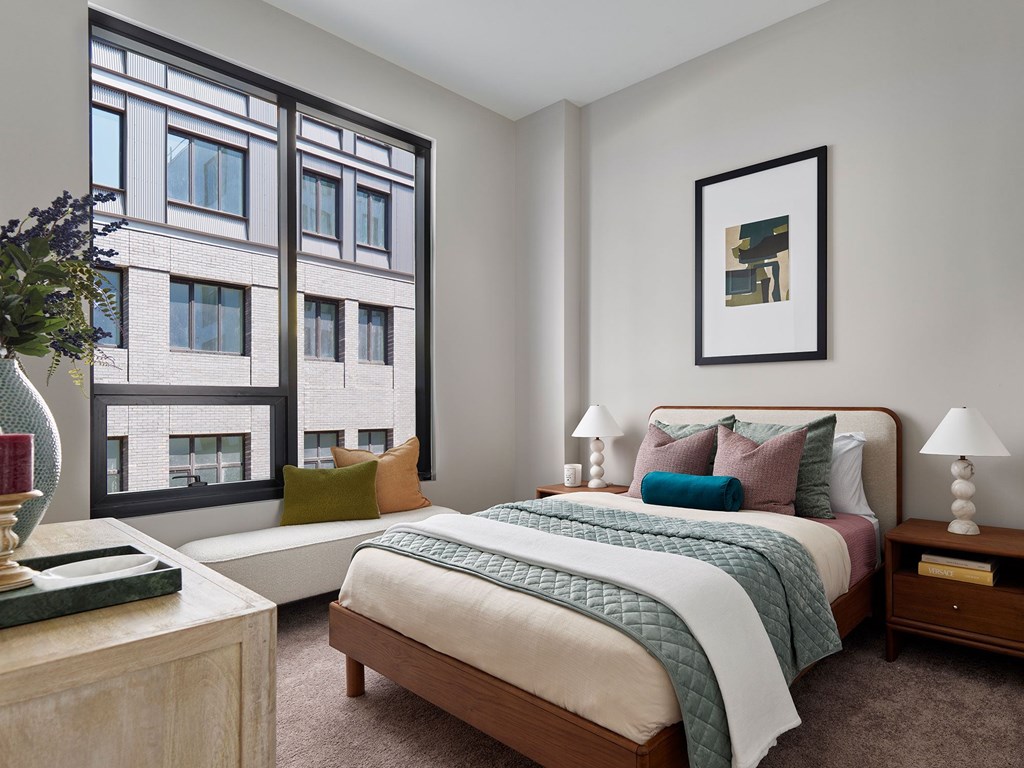 A bedroom with a large bed and a large window.