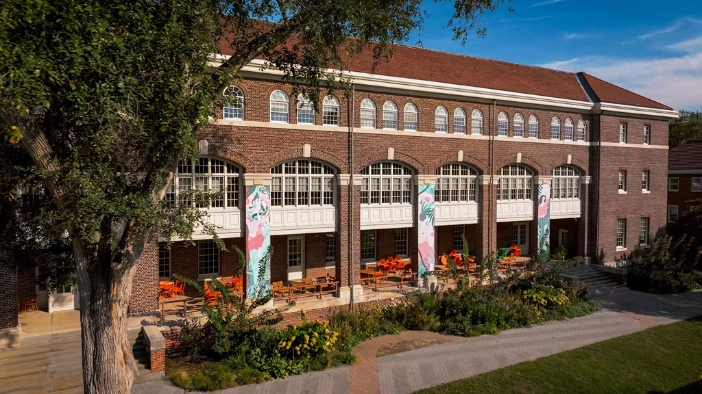 A large building with a red roof and a banner that says "The Best is Yet to Come" hangs above a patio area.