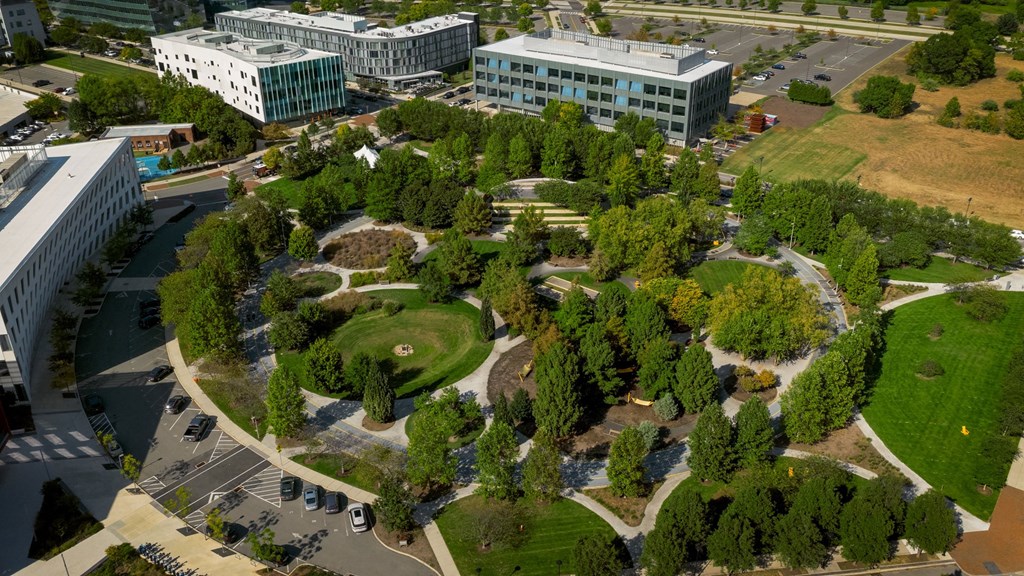 A large building complex with a circular green space in the middle.