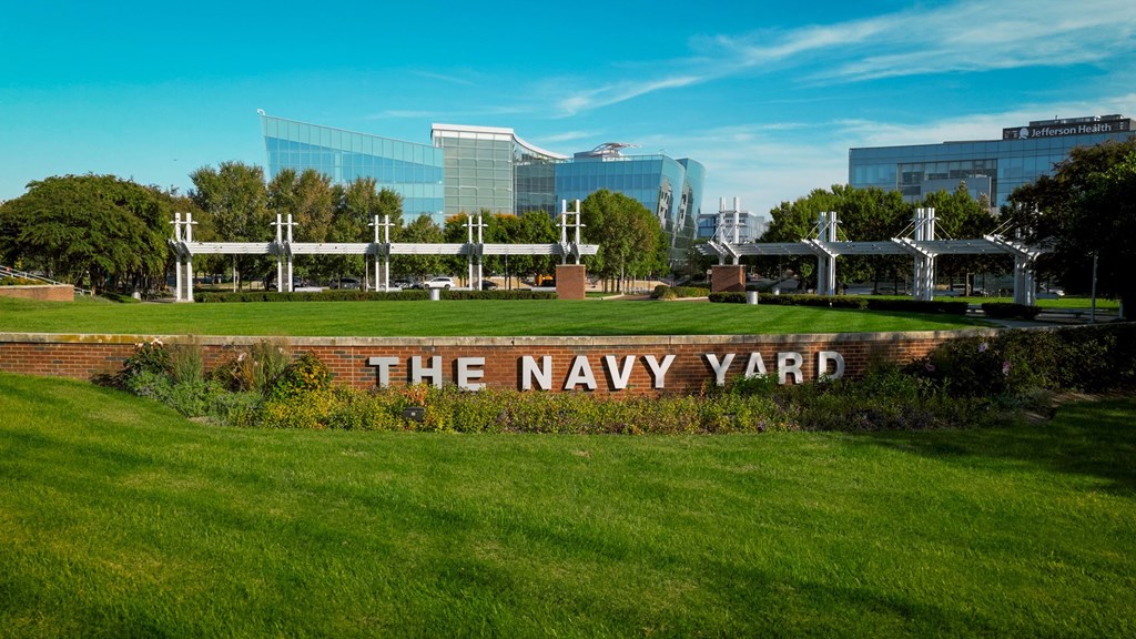A sign that says "The Navy Yard" is in front of a grassy area.