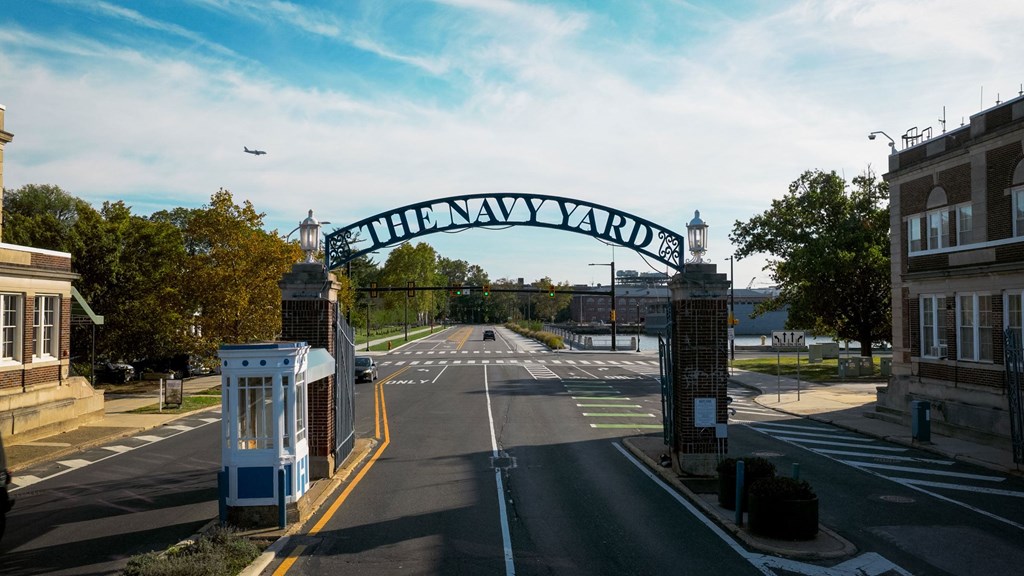 A street view of a city with a sign that reads "The Navy Yard".