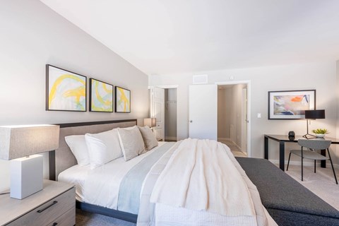 Natural light filled bedroom with large windows and luxurious carpet and ensuite bathroom