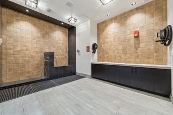 A bathroom with a tiled wall and a bench.