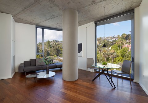 A living room with a grey couch and a white table.