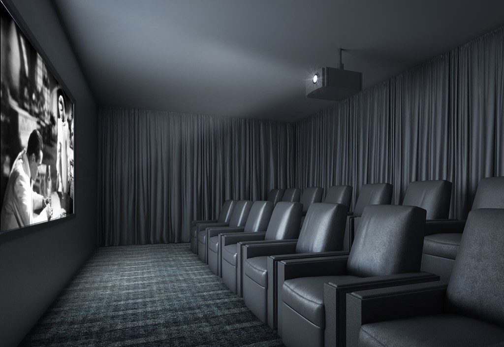a dark screening room with chairs and a movie screen