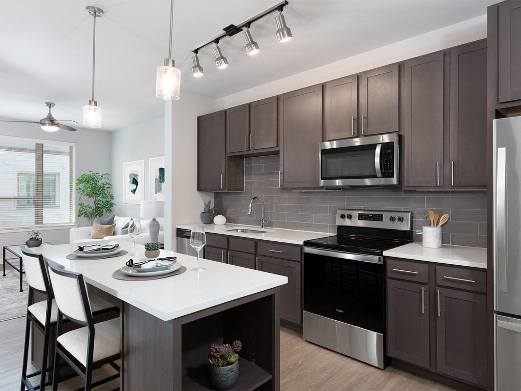 a kitchen with dark cabinets and a white island with a white countertop