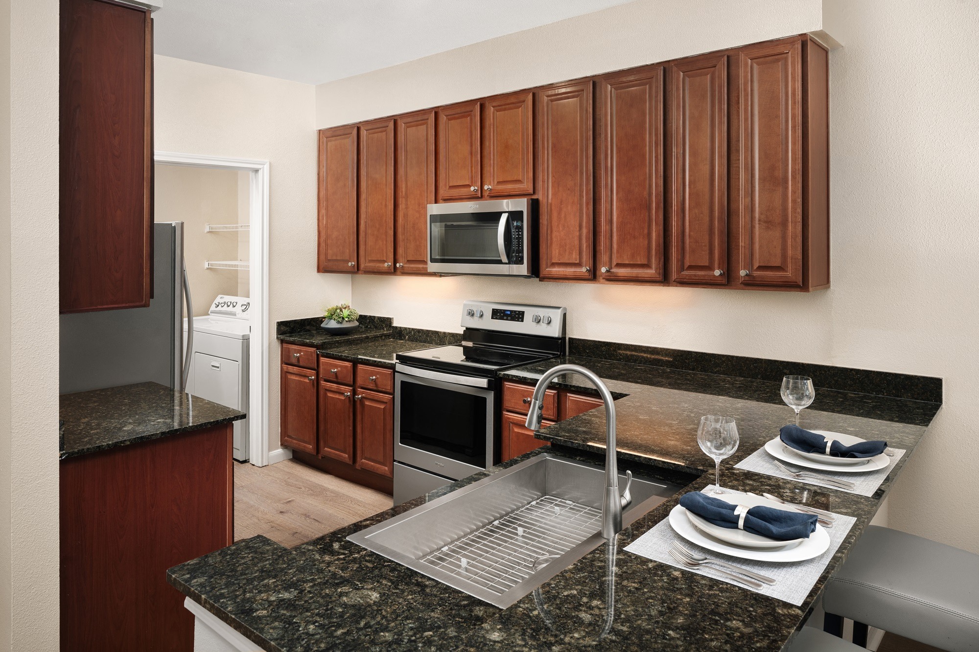 A kitchen with brown cabinets and a granite counter top.