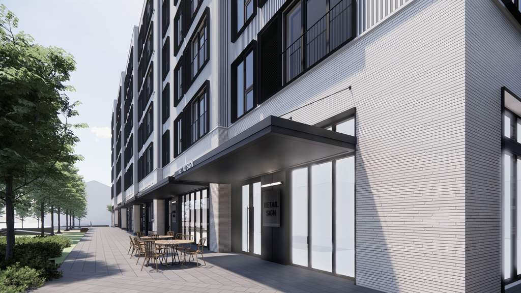 A modern building with a glass entrance and a wooden bench outside.