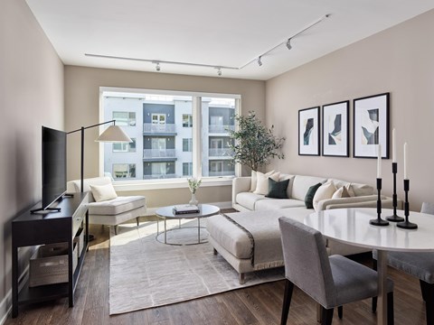A modern living room with a large window overlooking a building.