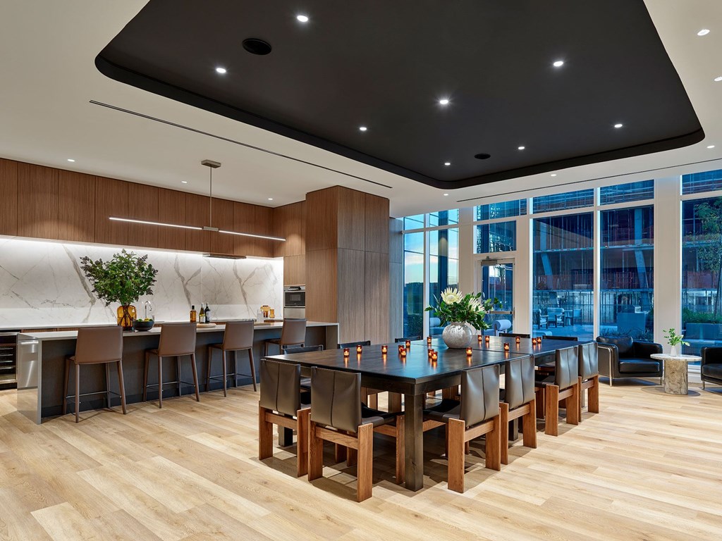 A modern dining room with a long table and chairs.