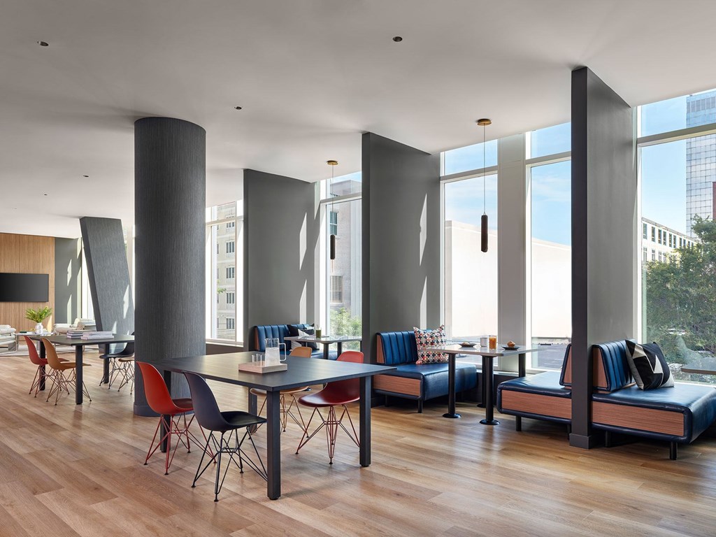 A modern dining room with a long table and chairs.