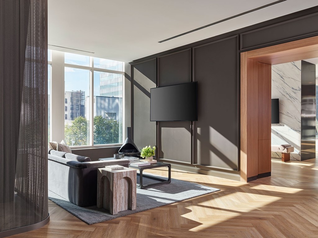 A modern living room with a large window and a wooden floor.