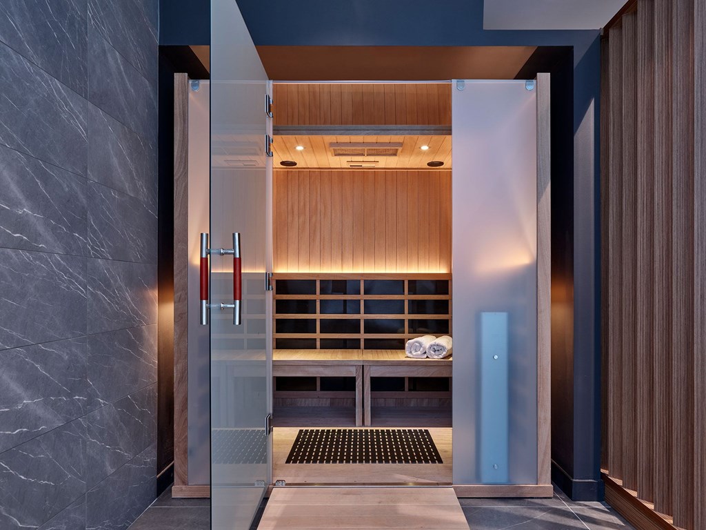 A modern bathroom with a walk-in shower and a glass door.