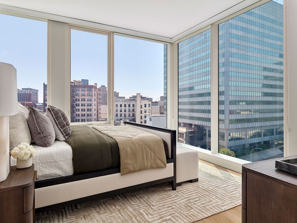 A bedroom with a large bed and a view of the city.
