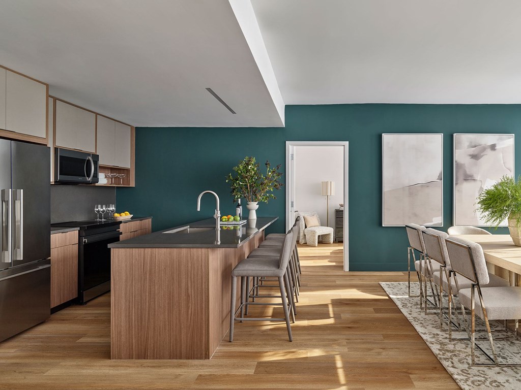 A modern kitchen with a wooden island and stainless steel appliances.